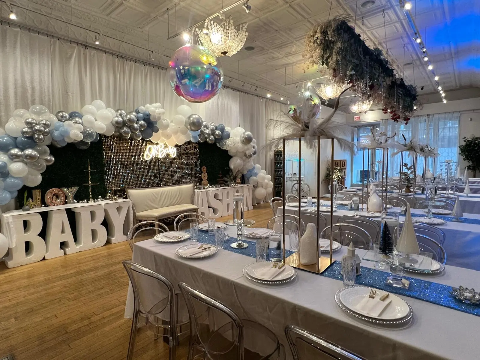 Baby shower in the hall with balloon garland, sequin backdrop, and tin ceiling