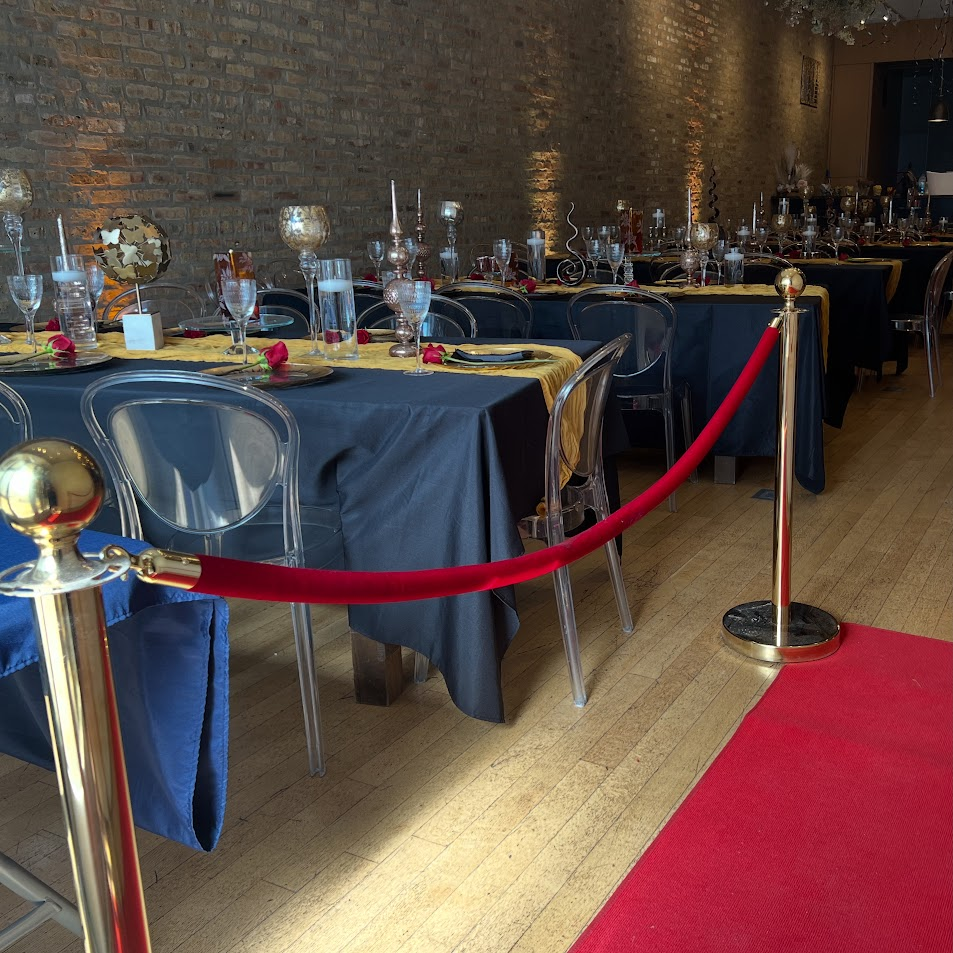 Navy and gold banquet tables behind a red velvet rope with a red carpet runner
