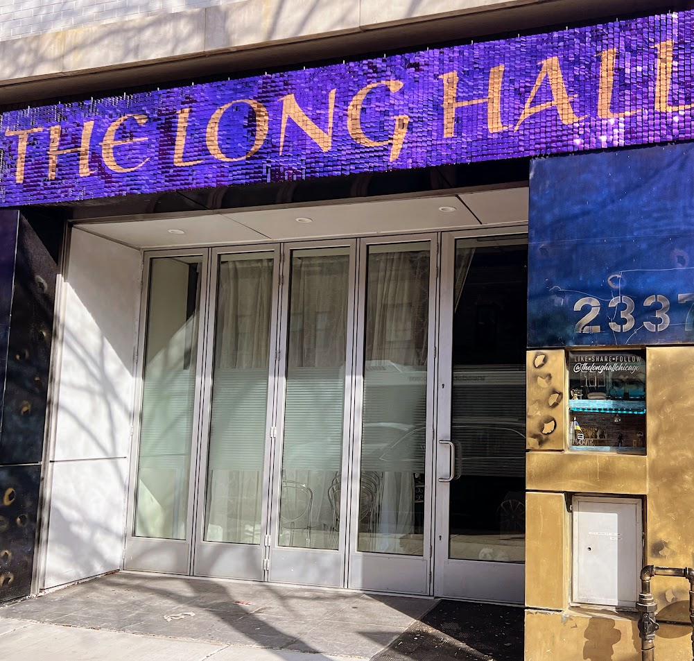 The Long Hall storefront on Milwaukee Avenue with purple sequin sign and glass doors